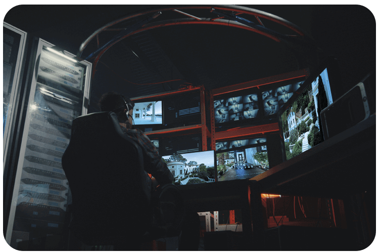 A dark control room featuring large screens showing live camera feeds in Phoenix, AZ.