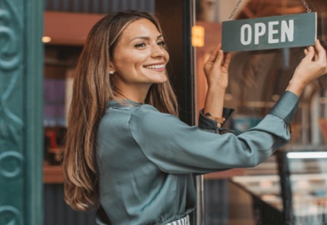 Small business owner at a storefront entrance